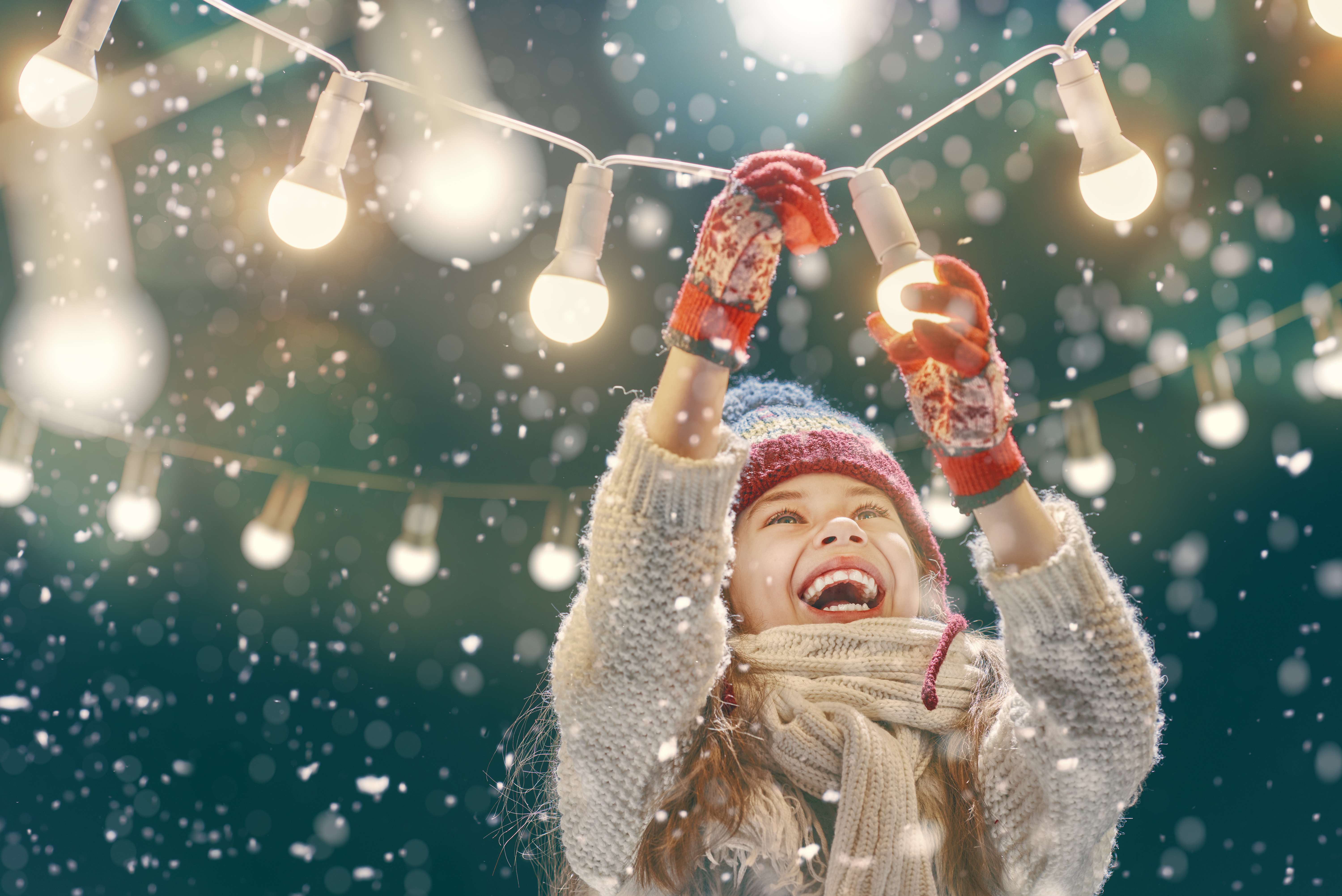 Child surrounded by warm holiday lights, capturing the magic of the season
